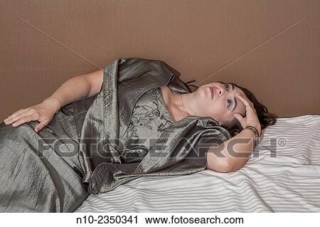 Woman in her mid-30's lying on her bed. View Large Photo Image Stock Image - Woman in her mid-30's lying on her bed.. Fotosearch