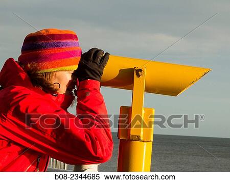 woman in winter clothes looking out to sea through a cliff-top telescope, Robin Hoods Bay, Yorkshire, Britain. View Large Photo Image Stock Photography - woman in winter clothes looking out to sea through a cliff-top telescope, Robin Hoods Bay, Yorkshire, Britain.. Fotosearch