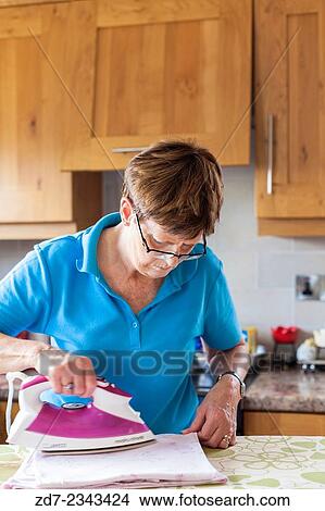 Woman ironing in kitchen. View Large Photo Image Picture - Woman ironing in kitchen.. Fotosearch