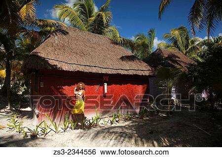 Stock Photograph - Woman posing in front of a hut, Tulum, Quintana Roo, Yucatan Province, Mexico, Central America.. Fotosearch