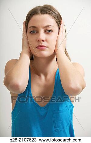 Young beautiful woman in a blue top, stopping both ears with her hands View Large Photo Image Stock Image - Young beautiful woman in a blue top, stopping both ears with her hands. Fotosearch