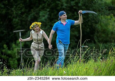 Young couple with an agricultural tool in the field. View Large Photo Image Picture - Young couple with an agricultural tool in the field.. Fotosearch