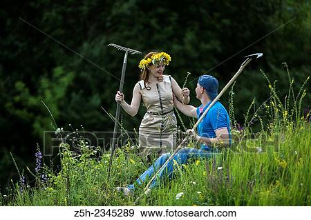 Stock Photo - Young couple with an agricultural tool in the field.. Fotosearch