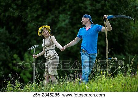 Stock Photography - Young couple with an agricultural tool in the field.. Fotosearch