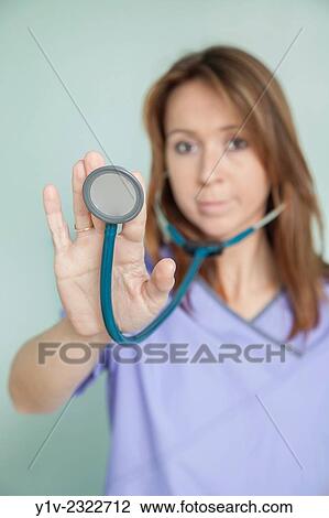 Young female nurse holding a stethoscope. View Large Photo Image Stock Image - Young female nurse holding a stethoscope.. Fotosearch
