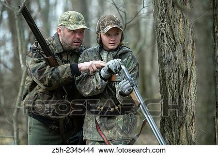 Young girl on the hunt with an experienced instructor in the forest. View Large Photo Image Picture - Young girl on the hunt with an experienced instructor in the forest.. Fotosearch