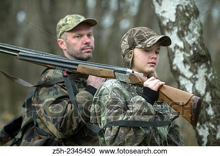 Stock Image - Young girl on the hunt with an experienced instructor in the forest.. Fotosearch