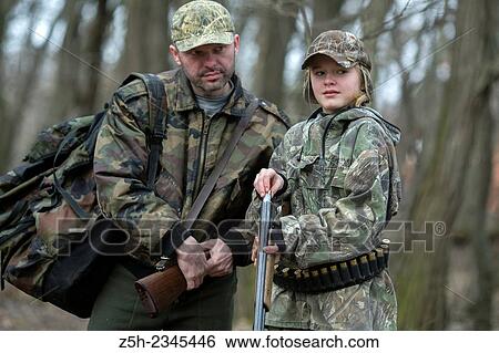 Stock Photograph - Young girl on the hunt with an experienced instructor in the forest.. Fotosearch