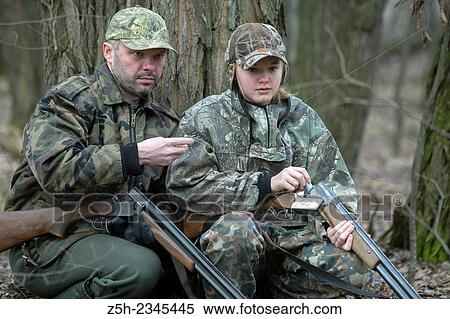 Stock Photography - Young girl on the hunt with an experienced instructor in the forest.. Fotosearch