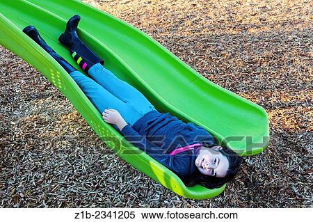 Young girl sliding down a playground slide in reverse. View Large Photo Image Stock Photography - Young girl sliding down a playground slide in reverse.. Fotosearch