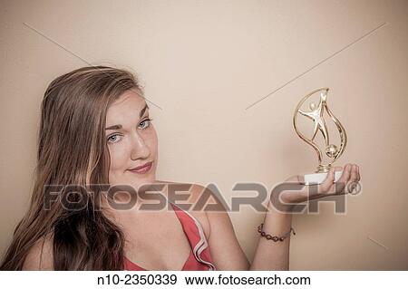 Young woman holding a trophy. View Large Photo Image Stock Photo - Young woman holding a trophy.. Fotosearch