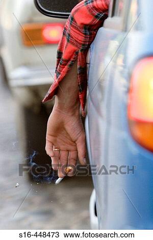 "A driver shakes the ashes of his lit cigarette while waiting cought in a traffic jam in downtown Bucharest, Magheru Boulevard - Romania" View Large Photo Image Stock Image - "A driver shakes the ashes of his lit cigarette while waiting cought in a traffic jam in downtown Bucharest, Magheru Boulevard - Romania". Fotosearch