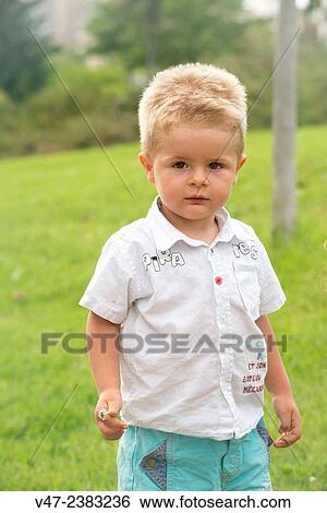 A little boy shyly smiling at the camera View Large Photo Image Stock Photograph - A little boy shyly smiling at the camera. Fotosearch