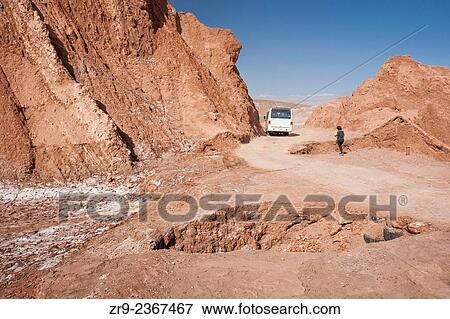 "Adult woman walks near giant holes in dusty road in Moon Valley, Atacama Desert, San Pedro, Chile, South America. " View Large Photo Image Stock Photo - "Adult woman walks near giant holes in dusty road in Moon Valley, Atacama Desert, San Pedro, Chile, South America. ". Fotosearch