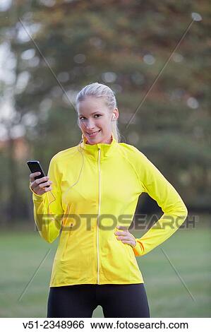 Blonde woman doing sport in park with and headphones smiling at camera View Large Photo Image Stock Photograph - Blonde woman doing sport in park with and headphones smiling at camera. Fotosearch