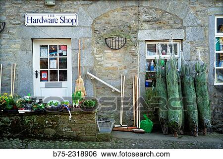 "Close up of the front of a hardware store with Christmas trees, brooms and plants, in the village of Grassington. Yorkshire Dales, Englang, UK, Europe" View Large Photo Image Stock Photograph - "Close up of the front of a hardware store with Christmas trees, brooms and plants, in the village of Grassington. Yorkshire Dales, Englang, UK, Europe". Fotosearch