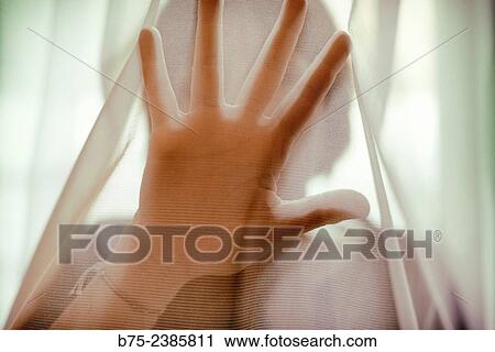 "Closeup of a hand in front of face, of a woman, in a position to stop behind a transparent curtain. " View Large Photo Image Stock Image - "Closeup of a hand in front of face, of a woman, in a position to stop behind a transparent curtain. ". Fotosearch