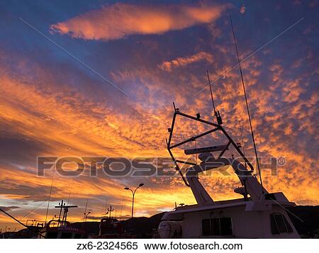 Stock Photography - "Colorful sunset with cirrocumulus clouds over Sant Carles de la Rapita fishing port. Ebro River Delta Natural Park, Tarragona province, Catalonia, Spain. ". Fotosearch