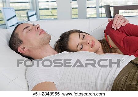 Couple relaxing on sofa View Large Photo Image Stock Photography - Couple relaxing on sofa. Fotosearch