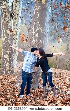 engaged kissing couple throwing up leaves View Large Photo Image Picture - engaged kissing couple throwing up leaves. Fotosearch