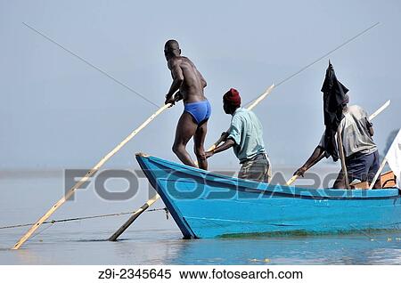 "Fishers pushing their boat through the water at Lake Victoria, Kenya. " View Large Photo Image Stock Photography - "Fishers pushing their boat through the water at Lake Victoria, Kenya. ". Fotosearch