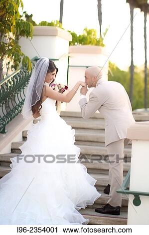 groom romantically kissing his brides hand on steps View Large Photo Image Stock Image - groom romantically kissing his brides hand on steps. Fotosearch