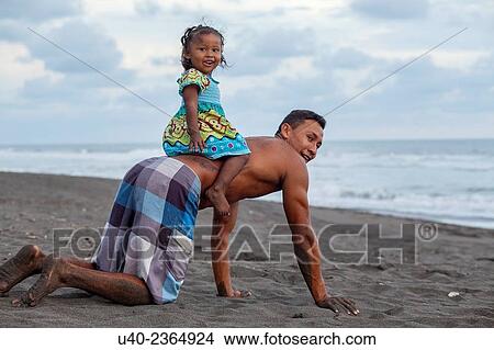 Picture - "Guatemala, Father and daughter playing on the beach. ". Fotosearch