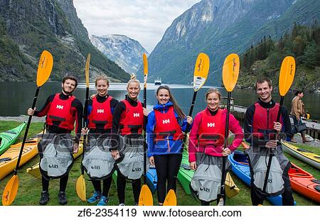 Stock Photo - Gudvangen Norway fjord called Naeroyforden Fjord portrait of college students getting lesson on paddling kayaks as sport MR-7.. Fotosearch