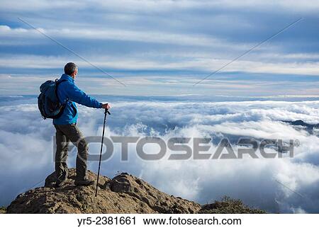 "Hiker at sunset on the highest point on Gran Canaria, Canary Islands, Spain. Pico de Las Nieves 1, 949 metres (6, 394 ft) is the highest point on Gran Canaria. " View Large Photo Image Stock Image - "Hiker at sunset on the highest point on Gran Canaria, Canary Islands, Spain. Pico de Las Nieves 1, 949 metres (6, 394 ft) is the highest point on Gran Canaria. ". Fotosearch