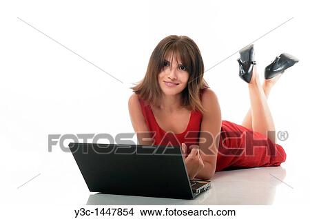 Hispanic woman working on computer while laying on a white floor View Large Photo Image Picture - Hispanic woman working on computer while laying on a white floor. Fotosearch