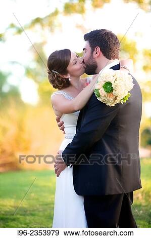 Stock Photo - "husband and wife passionately kissing, embracing on their wedding day". Fotosearch