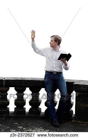 Stock Photo - Isolated image of a man sitting on balustrade with tablet computer and greeting / taking leave of somebody.. Fotosearch