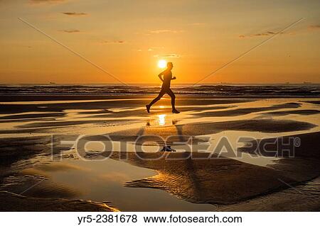 "Jogger at sunrise on Seaton Carew beach, north east Enngland. United Kingdom. " View Large Photo Image Stock Photo - "Jogger at sunrise on Seaton Carew beach, north east Enngland. United Kingdom. ". Fotosearch