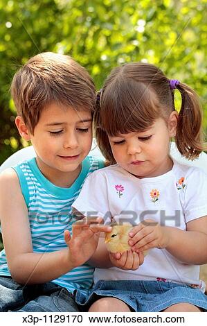 Stock Image - Kids with chick. Fotosearch