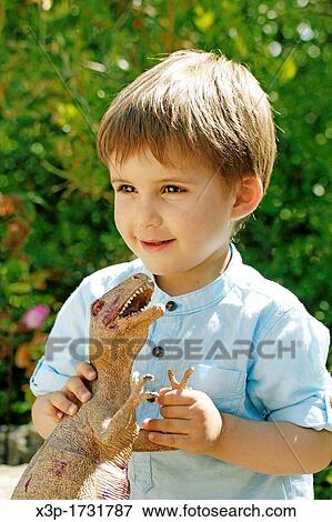 Little boy playing with a Tirannosaurus rex View Large Photo Image Stock Photo - Little boy playing with a Tirannosaurus rex. Fotosearch