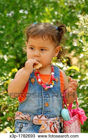 Little girl eating a cookie View Large Photo Image Stock Image - Little girl eating a cookie. Fotosearch