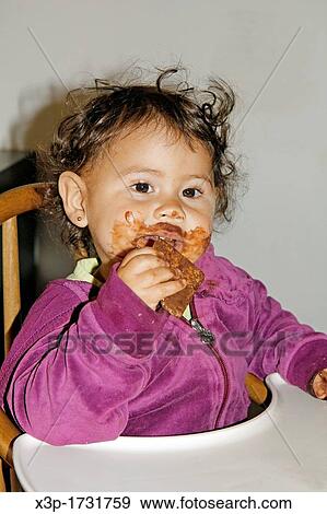 Little girl eating chocolate View Large Photo Image Stock Photo - Little girl eating chocolate. Fotosearch