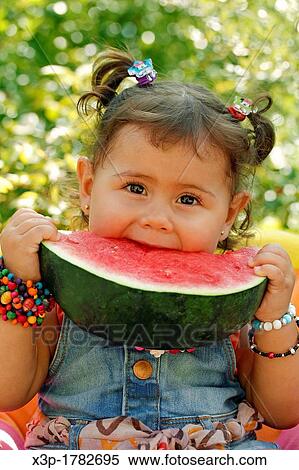 Stock Photography - Little girl eating watermelon. Fotosearch