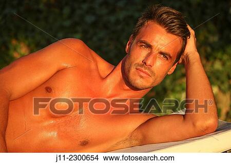 Man lying down on sunlounger View Large Photo Image Picture - Man lying down on sunlounger. Fotosearch