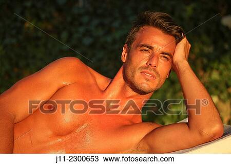 Man lying down on sunlounger View Large Photo Image Stock Image - Man lying down on sunlounger. Fotosearch