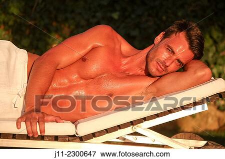 Man lying down on sunlounger View Large Photo Image Stock Photo - Man lying down on sunlounger. Fotosearch