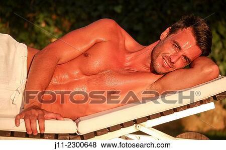 Man lying down on sunlounger View Large Photo Image Stock Photo - Man lying down on sunlounger. Fotosearch