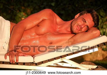 Man lying down on sunlounger View Large Photo Image Stock Photo - Man lying down on sunlounger. Fotosearch