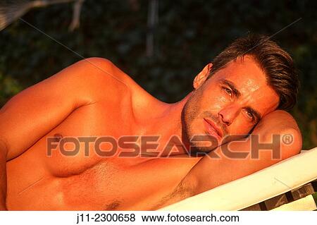 Man lying down on sunlounger View Large Photo Image Stock Photo - Man lying down on sunlounger. Fotosearch