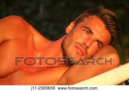 Man lying down on sunlounger View Large Photo Image Stock Photo - Man lying down on sunlounger. Fotosearch