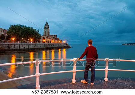 Stock Image - "Man on the promenade, night view. Gijon, Asturias, Spain. ". Fotosearch