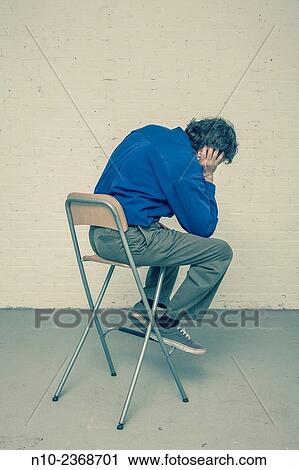 Stock Image - Man sitting in a chair.. Fotosearch
