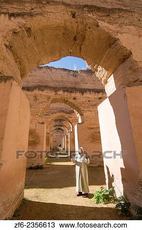 Meknes Morocco columns of Hri Souani former horse stalls in 17th century with arab man in robe in downtown with sunlight. View Large Photo Image Stock Image - Meknes Morocco columns of Hri Souani former horse stalls in 17th century with arab man in robe in downtown with sunlight.. Fotosearch