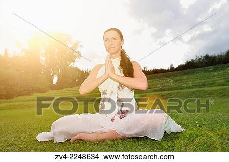 "Middle aged woman doing yoga in a park in summer, Germany. " View Large Photo Image Picture - "Middle aged woman doing yoga in a park in summer, Germany. ". Fotosearch