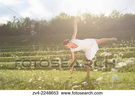 Stock Image - "Middle aged woman doing yoga in a park in summer, Germany. ". Fotosearch